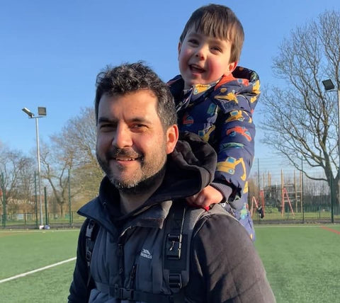 Dad carrying kid with Step Caddy child carrier