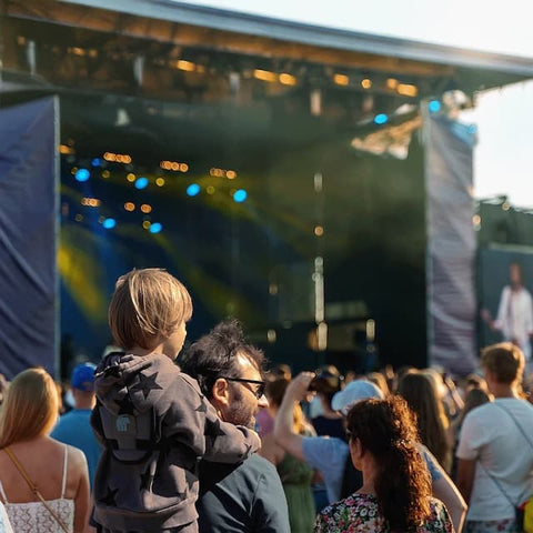Dad carrying kid with toddler carrier at festival