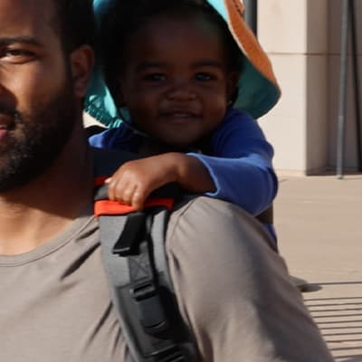 Step Caddy child carrier product feature highlight - showing the strap tunnels that protect the child's hands from the harness straps.