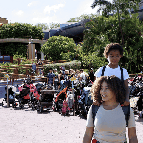 Mum carrying her large toddler at a theme park using a piggyback child carrier