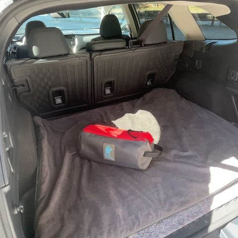 Car trunk with a folded and packed Toddler Carrier that pack up small.
